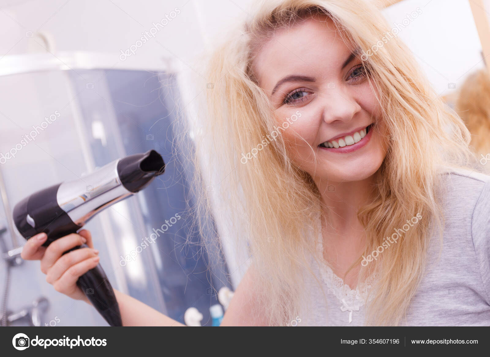 Mão de menina segurando o secador de cabelo.