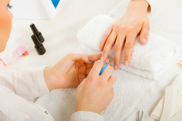 Woman hand on towel, beautician file nails. Beauty wellness spa treatment, manicure concept