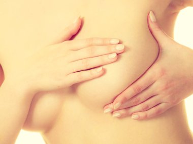 Sağlık hizmeti tıbbi konsepti. Meme uçlarında yumru ya da göğüs kanseri belirtileri var mı diye bakan genç bir kadın.