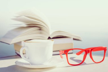 Tatillerde kitap okumak. Kahve fincanı ve açık havada kitap. Dinlenme dinlenme tatili kavramı.