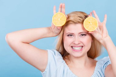 Sağlıklı beslenme, vitamin dolu ferahlatıcı yiyecekler. Lezzetli narenciye meyvesi tutan kadın, limon yarısı.