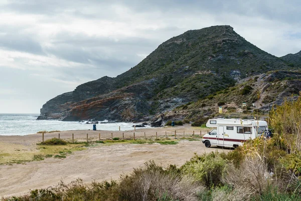 Camper car on spanish beach. Cala Reona in Cabo de Palos, Murcia region. Tourist site. Travel in motor home
