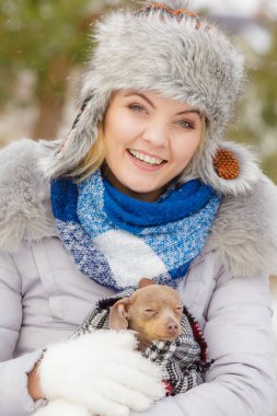 Genç bir kadın soğuk kış gününde en iyi arkadaşını sıcak battaniye eşarbına sardı. Hayvan koruma programı. Evlat edinme kavramı