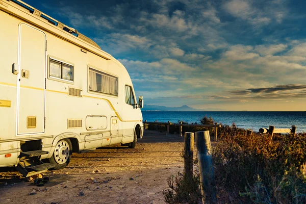 Camper, recreational vehicle on mediterranean coast in Spain. Camping on nature beach. Holidays and travel in motor home.