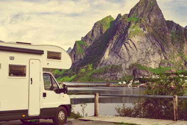 Yaz mevsiminde Reine köyü, Lofoten Norveç 'te karavan evi ve fiyort manzarası. Doğada kamp yapmak. Tatiller ve karavanla seyahat.