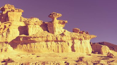 The Enchanted City of Bolnuevo, yellow sandstone shapes, rock formations, Murcia Spain. Tourist attraction. clipart