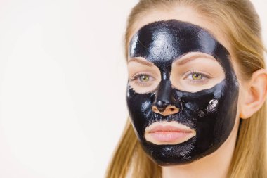 Yüzünde, beyaz karbonhidrat temizleme maskesi olan genç bir kadın. Genç kız yağlı cildiyle ilgileniyor, gözenekleri temizliyor. Güzellik tedavisi. Cilt bakımı.