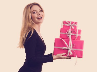 İnsanlar Xmas 'ın aşk ve mutluluk konseptini kutluyor. Neşeli sarışın kız elinde hediyeler pembe hediye kutuları, yan görüş.