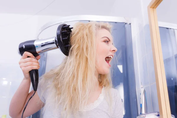 ヘアケア バスルームで髪を乾燥美容長い髪ブロンドの女性 笑顔の女の子が髪を使用してぬれた頭の上に風を吹いて ディフューザーノズルでカールを行う — ストック写真