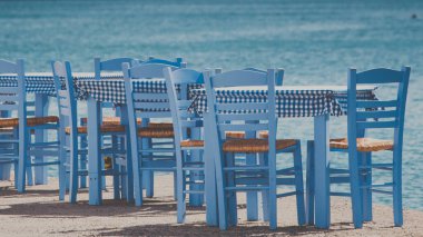 Deniz kenarındaki mavi masa ve sandalyeler deniz kıyısında Yunanistan 'da açık bir kafe restoranı açıyor. Yaz tatili.