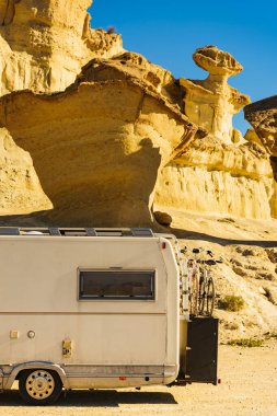 Aşınmış sarı kumtaşı oluşumlarındaki park yerinde kamp arabası, Büyülü Şehir Bolnuevo, Murcia İspanya. Turist eğlencesi.