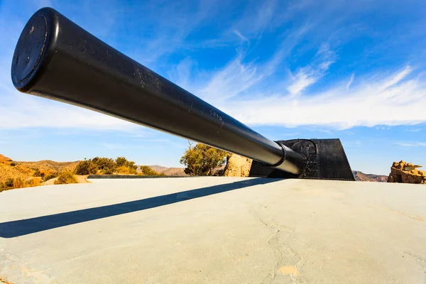 A vintage photograph of soldiers operating a large gun on a coastal defense battery