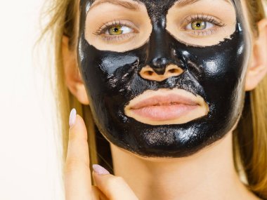 Yüzünde, beyaz karbonhidrat temizleme maskesi olan genç bir kadın. Genç kız yağlı cildiyle ilgileniyor, gözenekleri temizliyor. Güzellik tedavisi. Cilt bakımı.