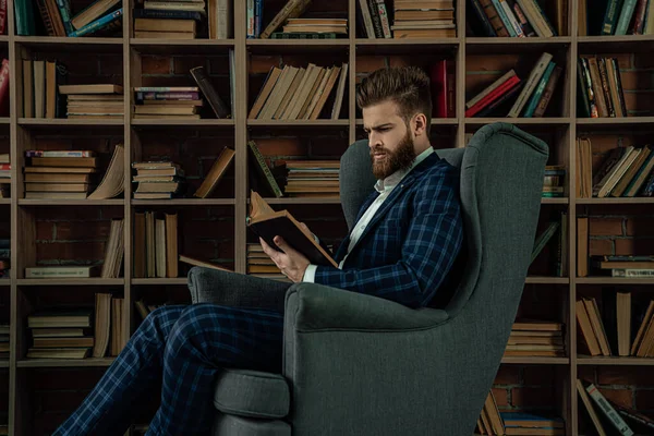 Elegante hombre en un traje sentado en habitación vintage y libro de lectura. Hombre de moda . —  Fotos de Stock