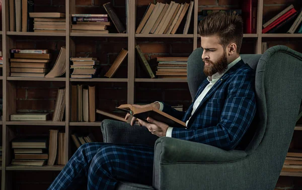 Elegante hombre en un traje sentado en habitación vintage y libro de lectura. Hombre de moda . —  Fotos de Stock