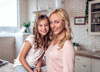 Mutlu anne-kız içki içiyor. Mutfakta sırlarını paylaşıyor.