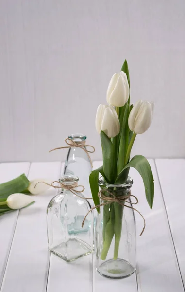 Tulipanes blancos en botella de vidrio — Foto de Stock