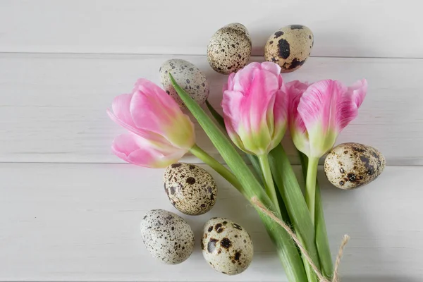 Hermosos tulipanes con huevos de codorniz sobre fondo de madera claro . — Foto de Stock