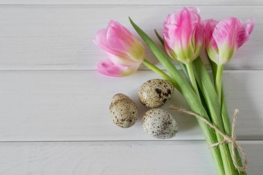 Güzel Lale ile ışık ahşap zemin üzerine bıldırcın yumurtası. Bahar ve Paskalya tatil kavramı.