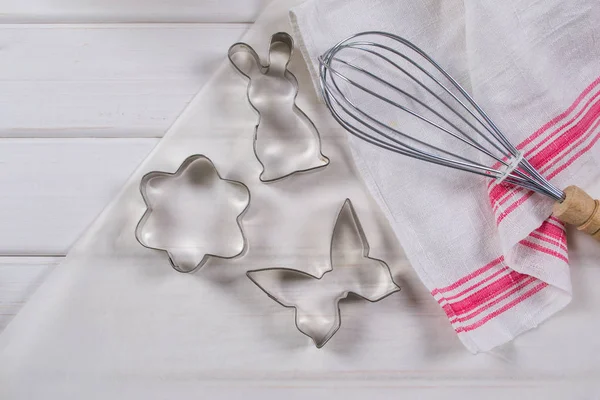 Cookie cutters  and kitchen tools on parchment paper