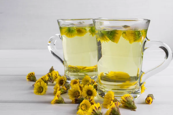 Two  cups of herbal tea with coltsfoot — Stock Photo, Image