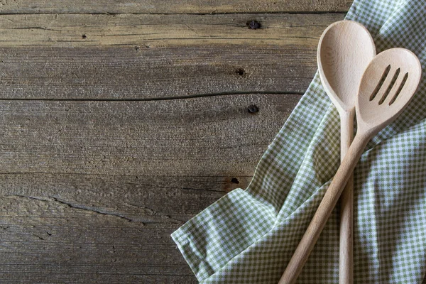 Servet en houten keukengerei op rustieke houten tafel. . Achtergrond voor een recept. — Stockfoto