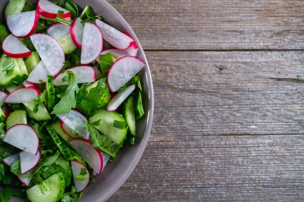 Витаминный весенний салат: зеленый лук, редис, огурец, руккола  . — стоковое фото