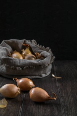 Çuvala ahşap masanın üzerine soğan ile.