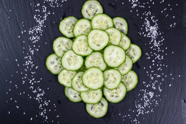 Gurkenscheiben auf der schwarzen Schiefertafel, — Stockfoto