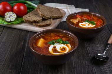 Domates çorbası. Geleneksel Ukrayna pancar ve domates çorbası - borsch ekşi krema, sarımsak, otlar ve ekmek ile kil tencerede. Maddeler tablosundaki