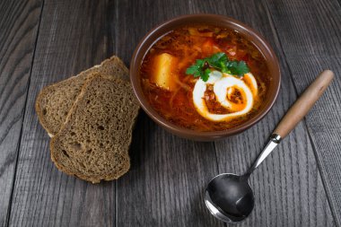 Domates çorbası. Geleneksel Ukrayna pancar ve domates çorbası - borsch ekşi krema, otlar ve ekmek ile toprak kap içinde