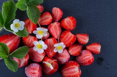Taze çilek dilimlenmiş siyah arduvaz kurulu, üstten görünüm