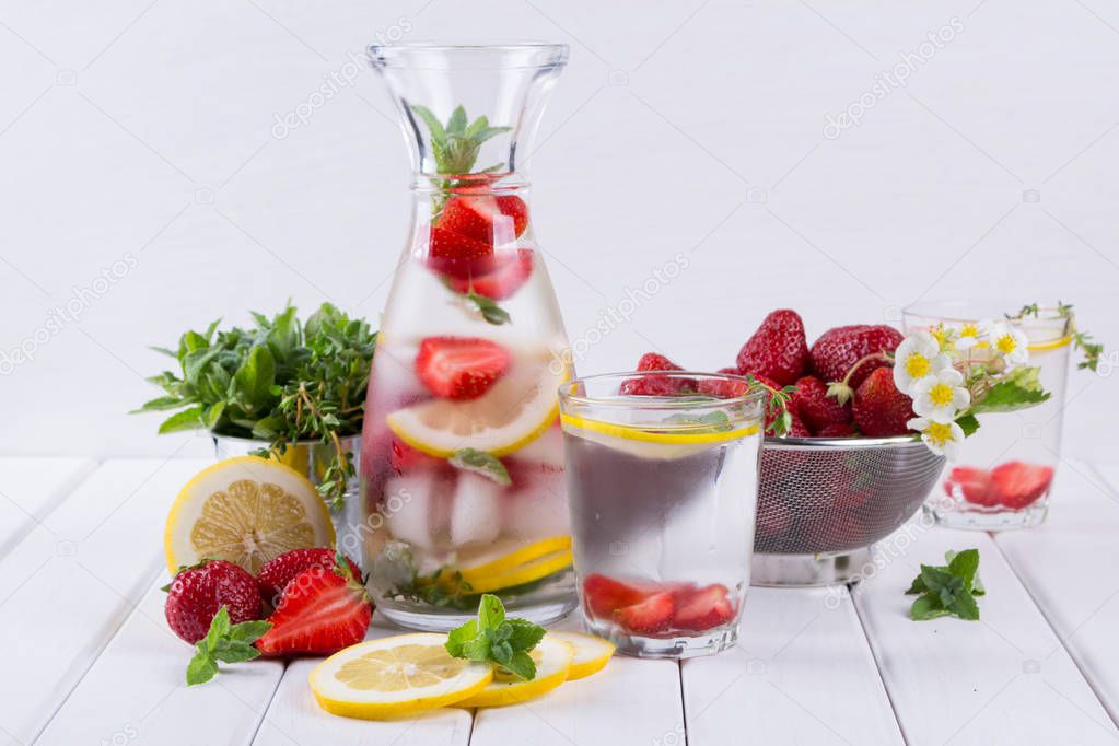 Mineral infused water with strawberry, ice, herb and mint leaves on white background, homemade detox soda water