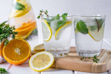 Maden suyu bir limon dilimleri ve Beyaz ahşap zemin üzerine nane