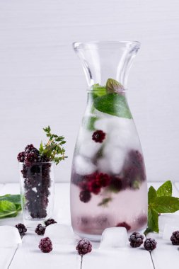 Mineral su beyaz arka plan, ev yapımı Detoks soda su üzerinde blackberry, buz, ot ve nane yaprakları ile infüzyon