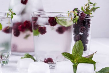 Mineral su beyaz arka plan, ev yapımı Detoks soda su üzerinde blackberry, buz, ot ve nane yaprakları ile infüzyon