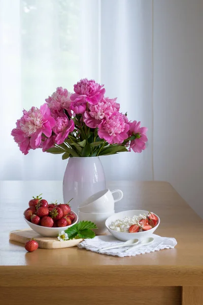 Nature morte des produits agricoles. Petit déjeuner léger avec des fraises fraîches fromage cottage Pivoine fleurs . — Photo