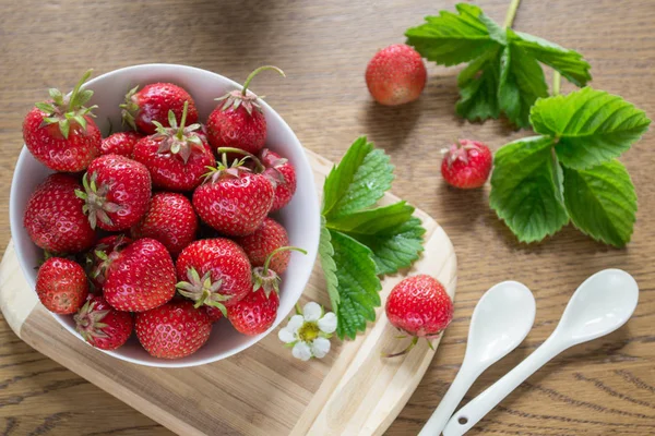 Strawberry leaves and flowers  on the kitchen table. — Stock Photo, Image