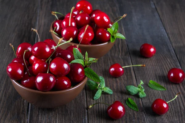 Fresh cherries in  clay bowl on  dark table — Stock Photo, Image