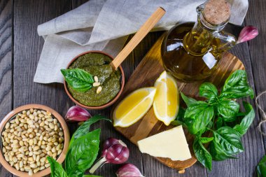 Ev yapımı Pesto tarifi Malzemeler karanlık masada. Parmesan peyniri, fesleğen yaprağı, çam fıstığı, zeytin yağı, sarımsak.