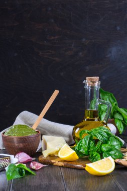 Ev yapımı Pesto tarifi Malzemeler karanlık masada. Parmesan peyniri, fesleğen yaprağı, çam fıstığı, zeytin yağı, sarımsak.