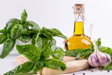 Sarımsak ve beyaz masaya zeytin yağı ile yeşil taze fesleğen