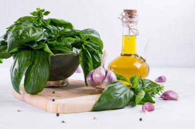 Sarımsak ve beyaz masaya zeytin yağı ile yeşil taze fesleğen