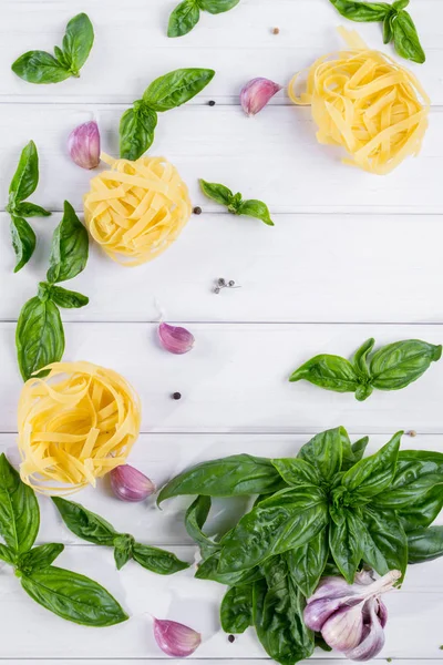 Düz yatıyordu. Pişmemiş makarna ve sarımsaklı beyaz masada yeşil taze fesleğen