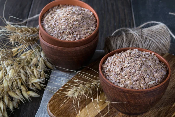 Wheat, Oat bran in clay  bowl and ears of wheat and oat.  Dietary supplement to improve digestion.