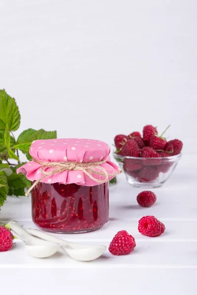 Raspberry jam in glass jar, fresh  ripe raspberry and green leaves — Stock Photo, Image