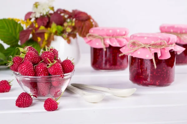 Raspberry jam in glass jar, fresh  ripe raspberry and green leaves — Stock Photo, Image