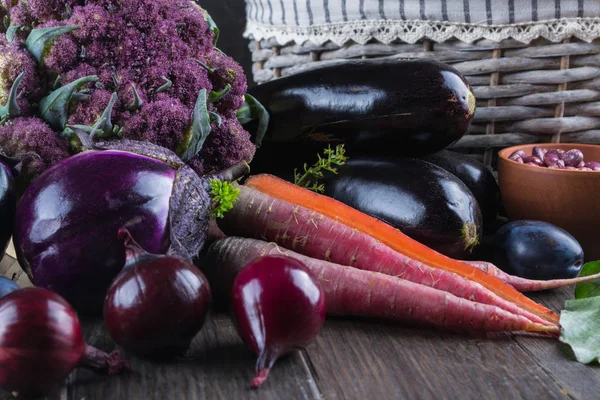 Ассортимент свежих фиолетовых овощей на тёмном деревянном столе — стоковое фото
