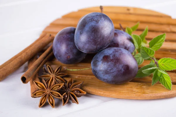 Group of fresh purple  plums on a white kitchen table — Stock Photo, Image