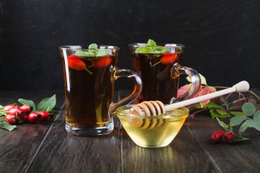 Sağlıklı sonbahar çay şube meyveleri koyu arka plan üzerinde ile köpek Güllü.